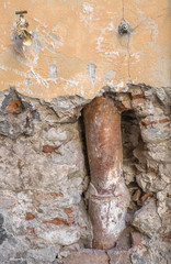 Old gutter inside the broken wall