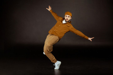 Fototapeta na wymiar Young and handsome man in beige clothes standing in dance pose