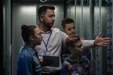 IT technician showing around children in a server park