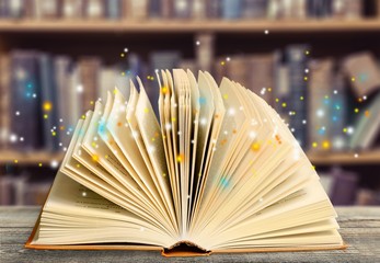 Open book on old wooden table.