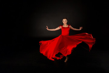 Young beautiful girl in red waving flying dress