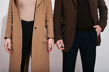 They belong together. Well-dressed couple posing in studio. Close up.