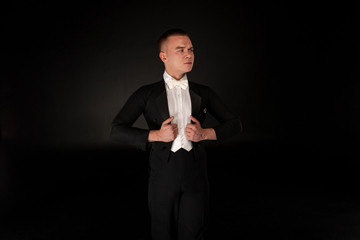 Serious handsome young dancer in black suit