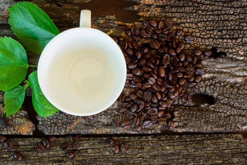 hot cappuccino on wood table /hot cappuccino with coffee bean and green leaf on wood table