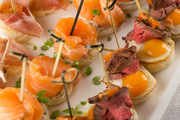 Festive Appetizer with quail egg, salmon and roast beef