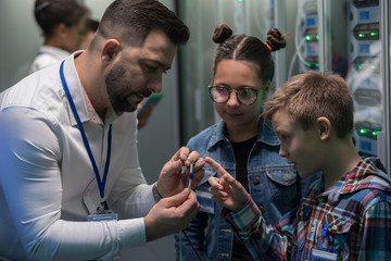 IT technician showing cable to children