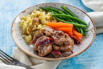 Pork in cranberry glaze with red onions, crushed potatoes and boiled vegetables