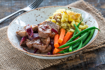 Pork in cranberry glaze with red onions, crushed potatoes and boiled vegetables