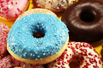 assorted donuts with chocolate frosted, pink glazed and sprinkles donuts