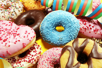 assorted donuts with chocolate frosted, pink glazed and sprinkles donuts