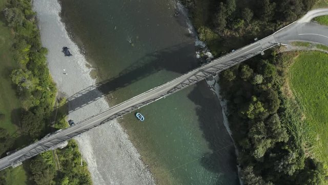Top down view of raft traveling under old bridge on Rangitikei ranges NZ 4k