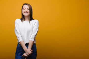 I want to win ! Beautiful young european girl wishing to win something dressed in casual clothes against yellow background.