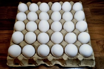 White eggs in corrugated cardboard packaging.