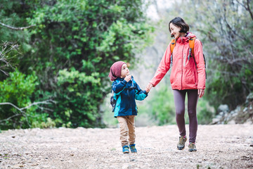 Fototapeta premium A woman walks with her son through the forest.