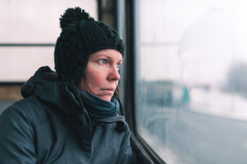 Sad woman on the bus looking through window