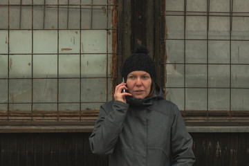 Worried woman talking on mobile phone on street