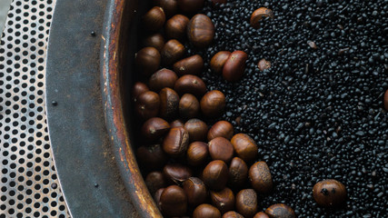 Cooking Roasted Chestnuts in a wok. The Chestnuts can classify in the street food category.