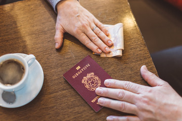 Male and female hands with passport and money on the table - concept of illegal immigration, sale...