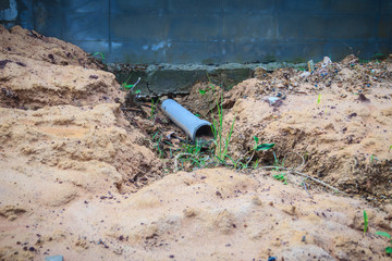 Fence wall of the newly built housing is tilted and collapsed due to high earthwork and heavy rainfall, causing the soil in the house to weaken and flow out with the water although there are drains.