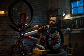 Fototapeta na wymiar Man working in a bicycle repair shop