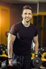 Fototapeta na wymiar Handsome muscular man working out hard at gym