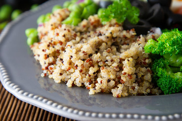 Quinoa salad with green pea,broccoli, olives. Healthy food, lunch over wooden background. Vegetarian food, snack.