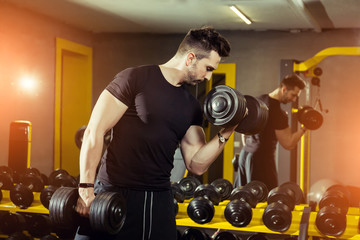 Handsome muscular man working out hard at gym