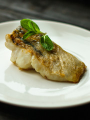 Fish, fried seafood (white fish on the plate). Food background