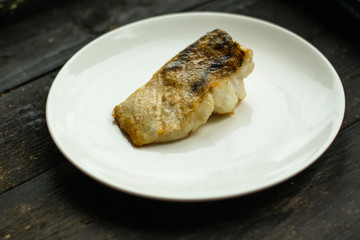 Fish, fried seafood (white fish on the plate). Food background
