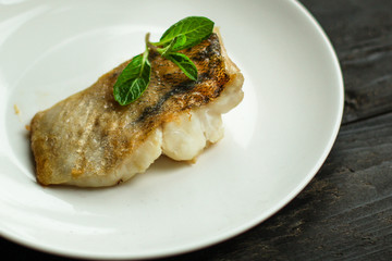 Fish, fried seafood (white fish on the plate). Food background