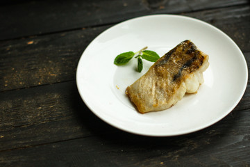 Fish, fried seafood (white fish on the plate). Food background