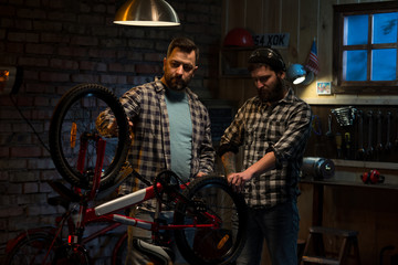 Fototapeta na wymiar Two men working in a bicycle repair shop