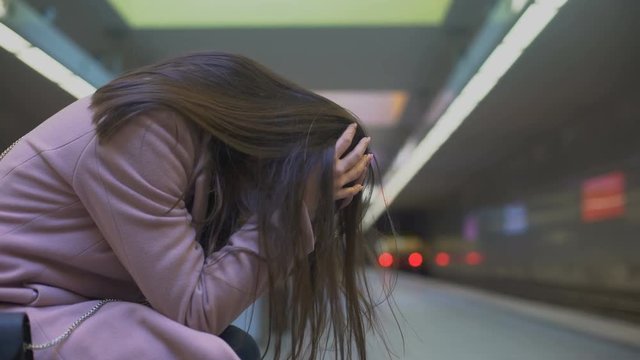 Desperate lady suffering anxiety attack at subway station, feeling helpless