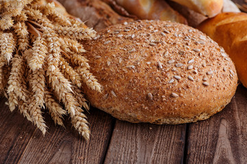 Assortment of baked bread on wooden table background