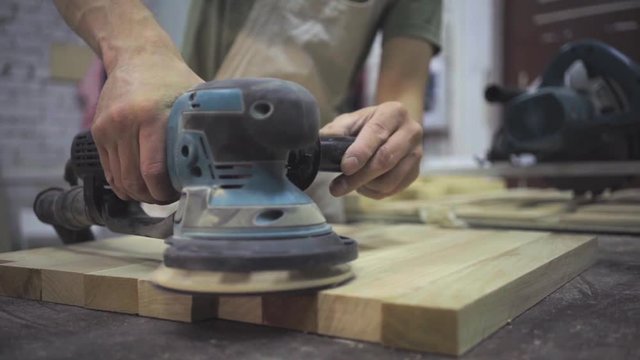 Man is craft working at a work bench with power tools