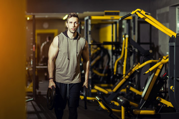 Handsome muscular man working out hard at gym