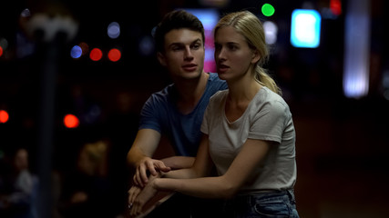 Young couple arguing and breaking down relationship, night street background