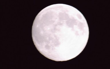 Genova, Italy - 10/24/2018: An amazing photography of the full  moon over the city of Genova by night with a great clear sky in background and some stars using high zoom.