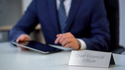 Chief financial officer of corporation using tablet pc, planning company budget