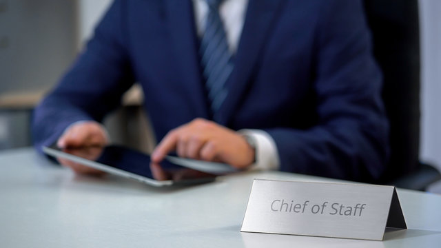 Young chief of staff working on tablet pc in office, solving corporate problems