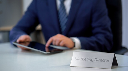 Successful marketing director working on tablet computer, developing media plan