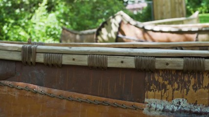 Slow motion focus shift on Native American birch bark canoes, from the front to the back.