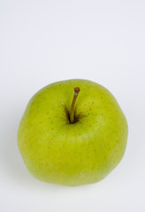 Grüner Apfel vor grauem Hintergrund im Hochformat