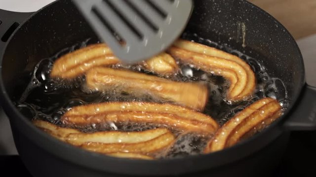 Cooking churos, dough churos in fried oil in a pan