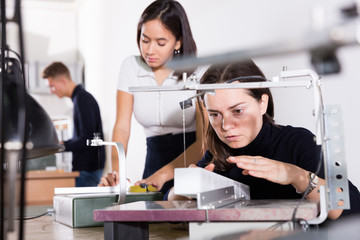 Woman working onscroll saw in architecture modeling workshop