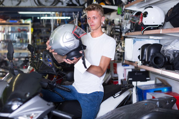 Motorcyclist is choosing helmet for motorbike