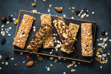 Granola bar with nuts, fruit and berries on black.