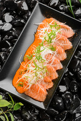 Salmon sashimi on black plate