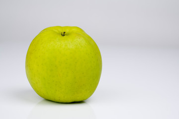 Grüner Apfel vor hellgrauem Hintergrund 