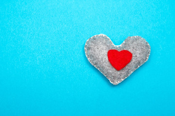 Obraz premium Felt handmade heart on a blue background. Top view.